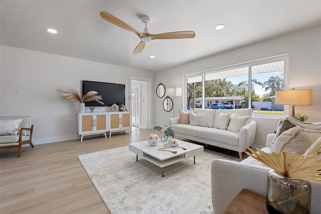 living room with light wood-type flooring and ceiling fan