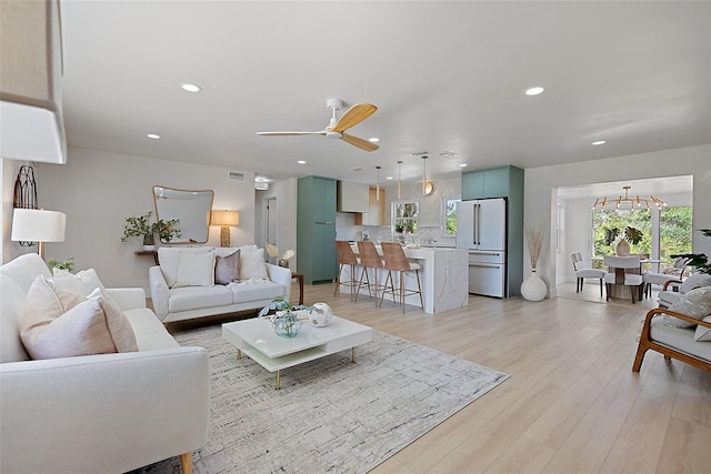 living room with ceiling fan and light hardwood / wood-style floors