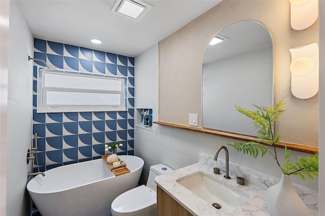 bathroom with vanity, toilet, tile walls, and a bathing tub