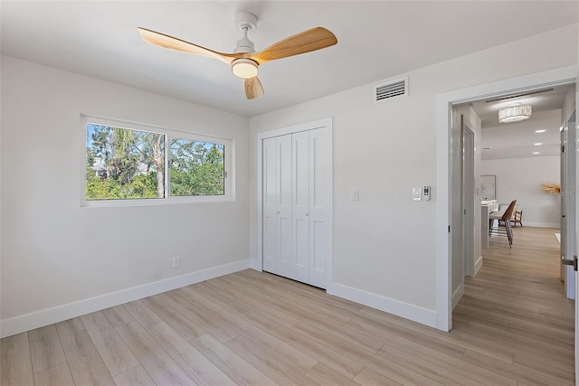 unfurnished bedroom featuring ceiling fan, a closet, and light hardwood / wood-style floors