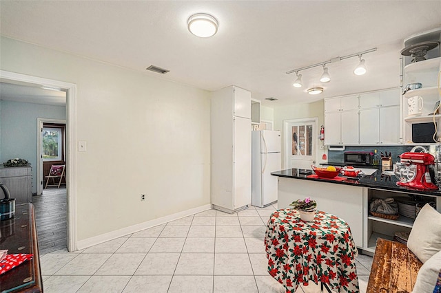 kitchen with backsplash, white cabinetry, light tile patterned floors, and white appliances