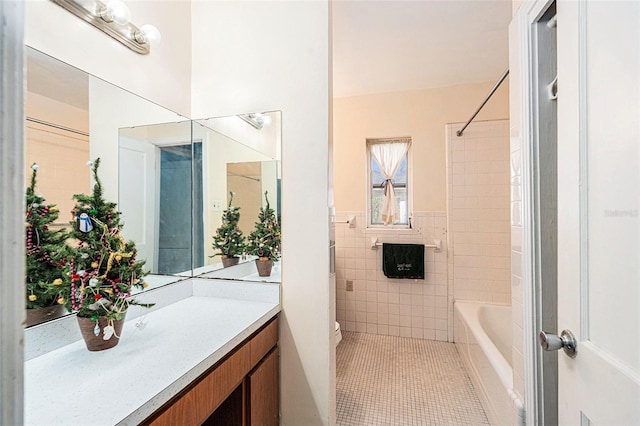 full bathroom featuring tile patterned flooring,  shower combination, toilet, vanity, and tile walls