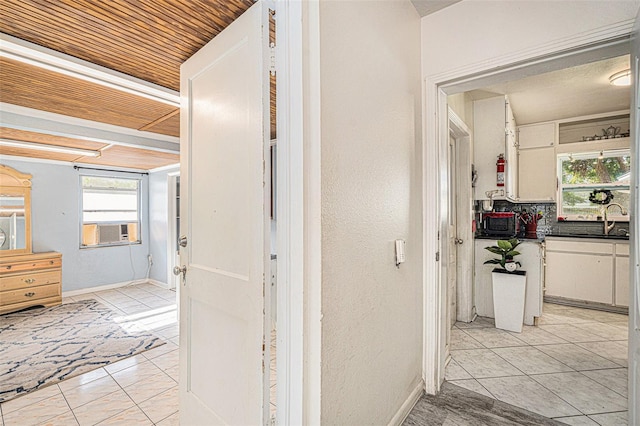 hall with cooling unit, wood ceiling, a healthy amount of sunlight, and sink