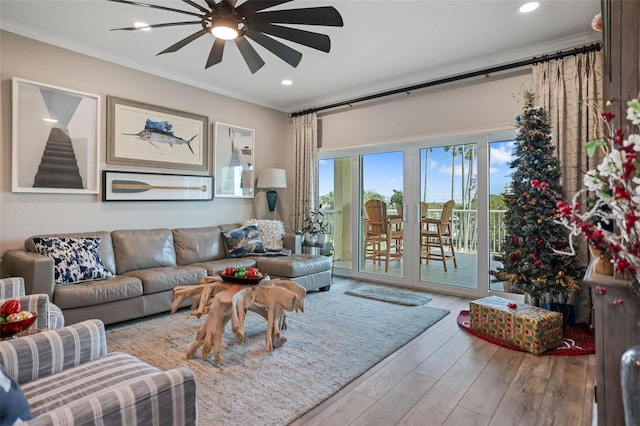 living room featuring hardwood / wood-style floors, ceiling fan, and ornamental molding