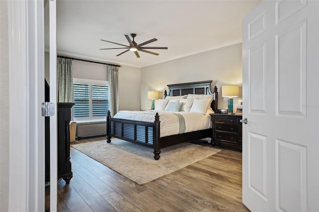 bedroom with hardwood / wood-style floors, ceiling fan, and ornamental molding