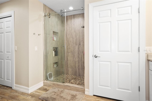 bathroom featuring hardwood / wood-style flooring and a shower with shower door