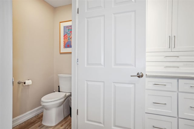 bathroom with hardwood / wood-style floors and toilet