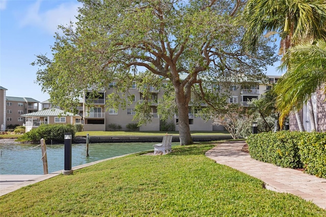 view of property's community with a lawn and a water view