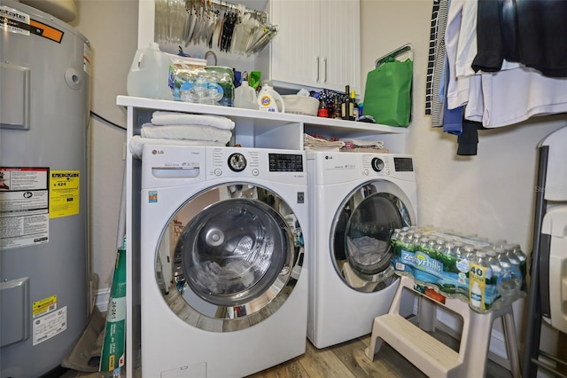 laundry area featuring washer and dryer, light wood-type flooring, and water heater