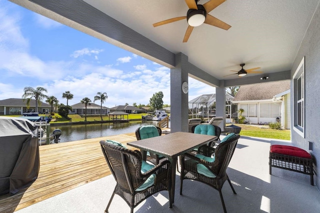 view of patio / terrace with ceiling fan, area for grilling, and a water view