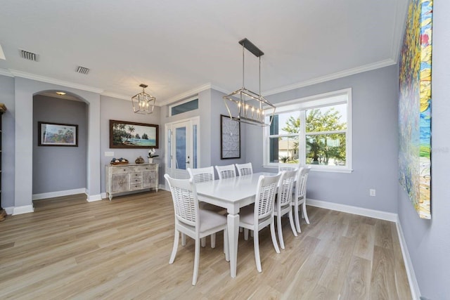 dining area with light hardwood / wood-style floors, ornamental molding, french doors, and a chandelier