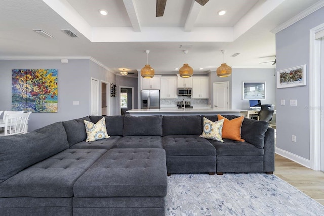 living room featuring ceiling fan, light hardwood / wood-style flooring, beamed ceiling, and crown molding