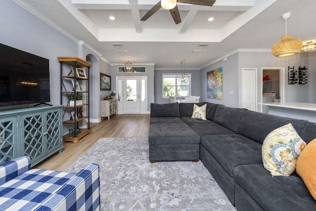 living room featuring beamed ceiling, light wood-type flooring, crown molding, and coffered ceiling