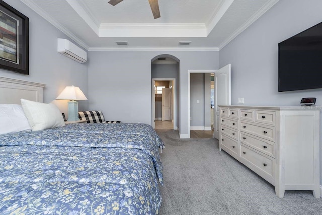 carpeted bedroom featuring a raised ceiling, a wall mounted AC, ornamental molding, and ceiling fan