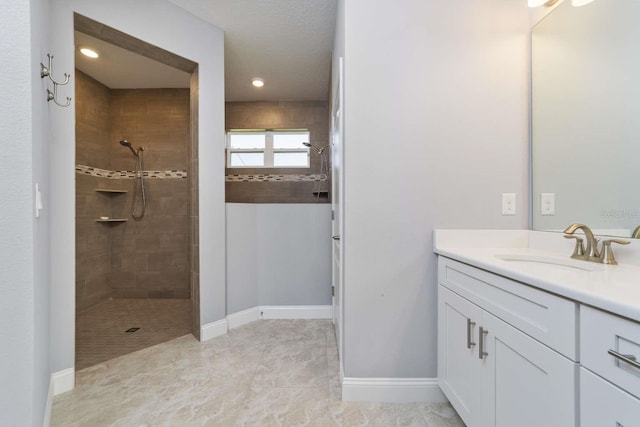 bathroom featuring vanity and tiled shower