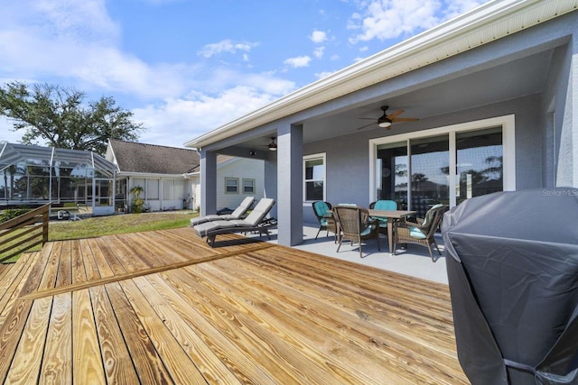 deck with glass enclosure, area for grilling, and ceiling fan