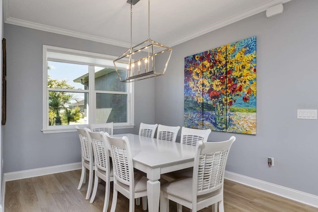 dining room with hardwood / wood-style floors, ornamental molding, and a chandelier