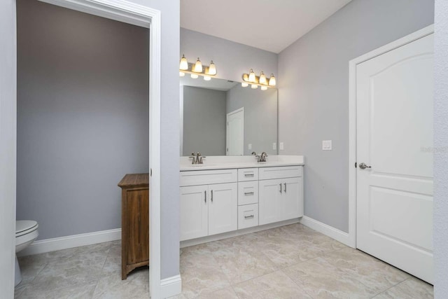 15 Cold Spring Ct, Palm Coast, FL 32137 - bathroom with double vanity, toilet, and baseboards