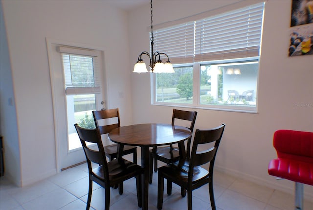 tiled dining area featuring plenty of natural light and a chandelier