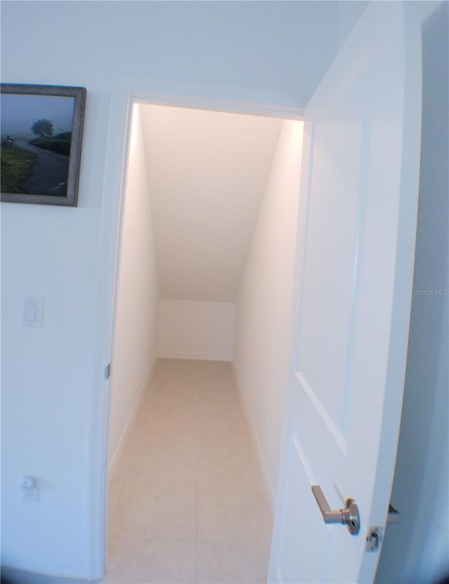 interior space featuring light tile patterned floors and vaulted ceiling