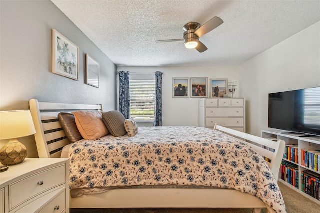 carpeted bedroom with ceiling fan and a textured ceiling