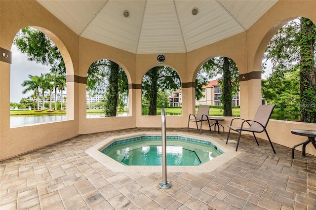 view of pool with a community hot tub and a water view