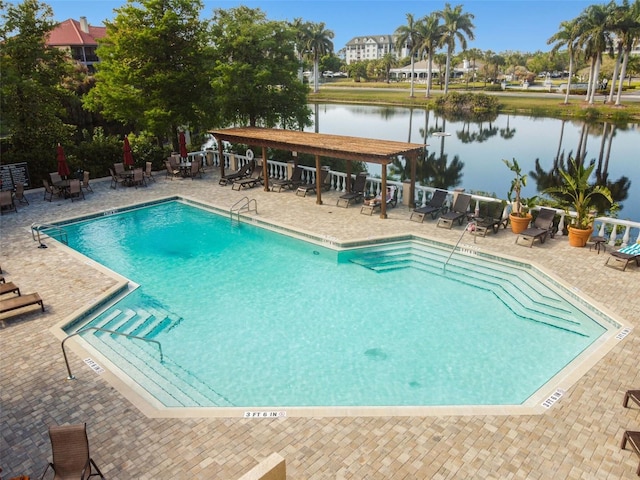 view of swimming pool featuring a water view and a patio area