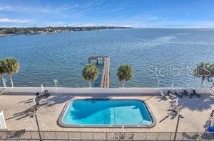 view of swimming pool with a water view and a patio area