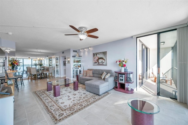 living room with floor to ceiling windows, ceiling fan, light tile patterned floors, and a textured ceiling