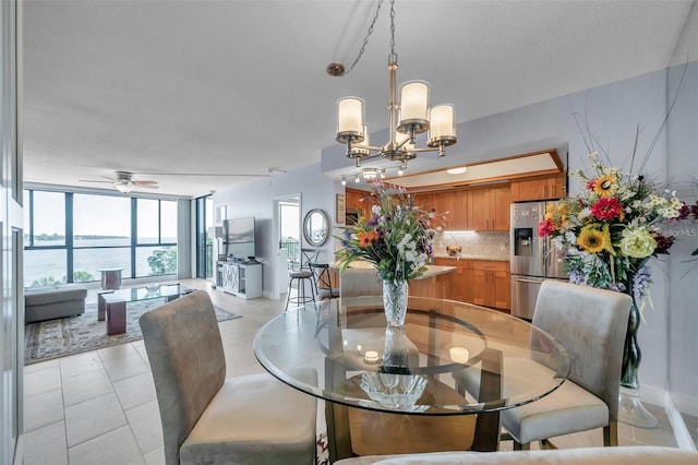 dining space featuring light tile patterned floors and ceiling fan with notable chandelier