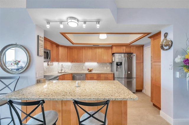 kitchen featuring a breakfast bar, kitchen peninsula, sink, and appliances with stainless steel finishes