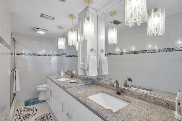 bathroom with tile patterned flooring, vanity, tile walls, and toilet