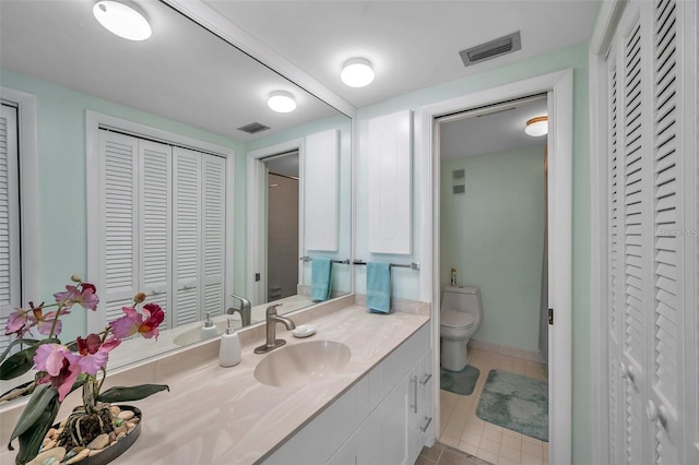 bathroom with tile patterned flooring, vanity, and toilet