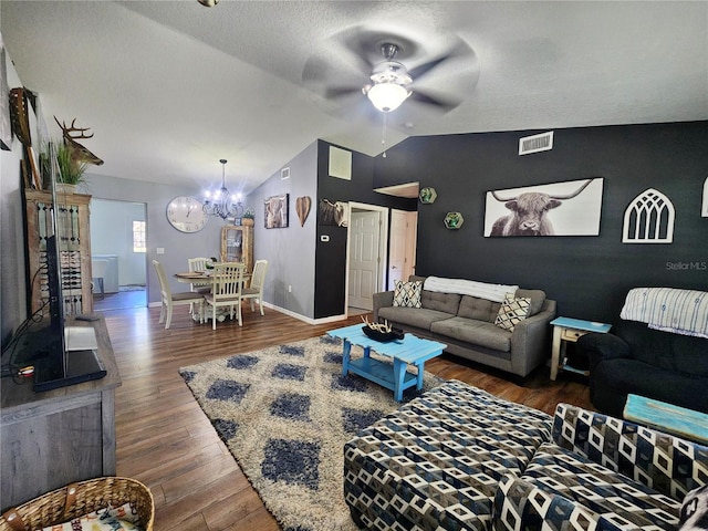 living room featuring ceiling fan with notable chandelier, dark hardwood / wood-style flooring, lofted ceiling, and a textured ceiling