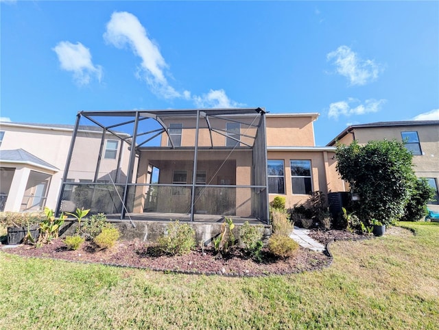 rear view of house with glass enclosure and a yard