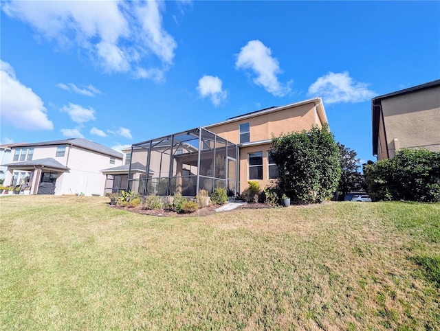 rear view of house featuring a lanai and a lawn