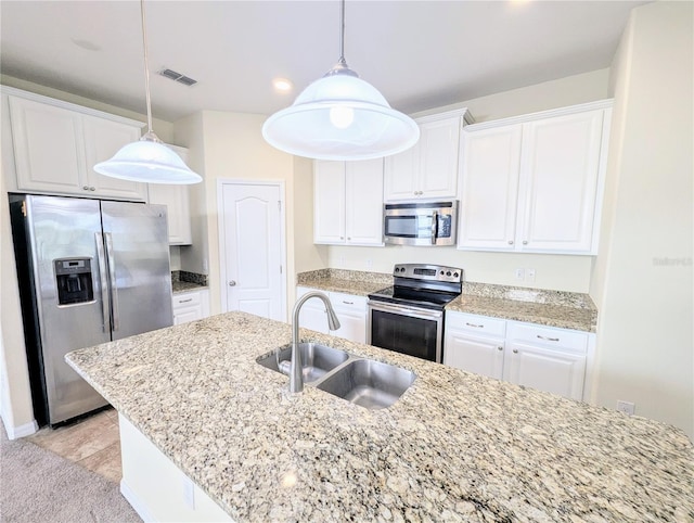 kitchen with sink, white cabinets, hanging light fixtures, and appliances with stainless steel finishes