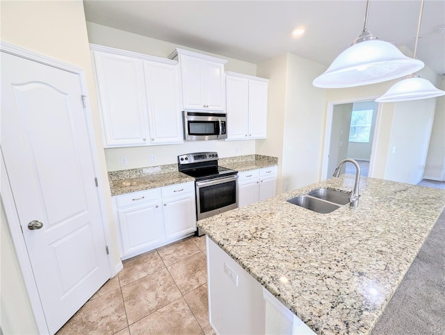 kitchen with a kitchen island with sink, white cabinets, sink, decorative light fixtures, and stainless steel appliances