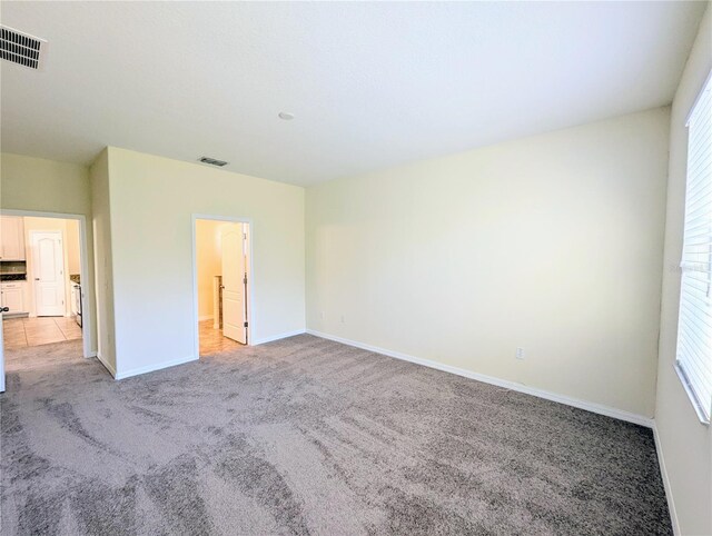 unfurnished bedroom with light carpet and multiple windows