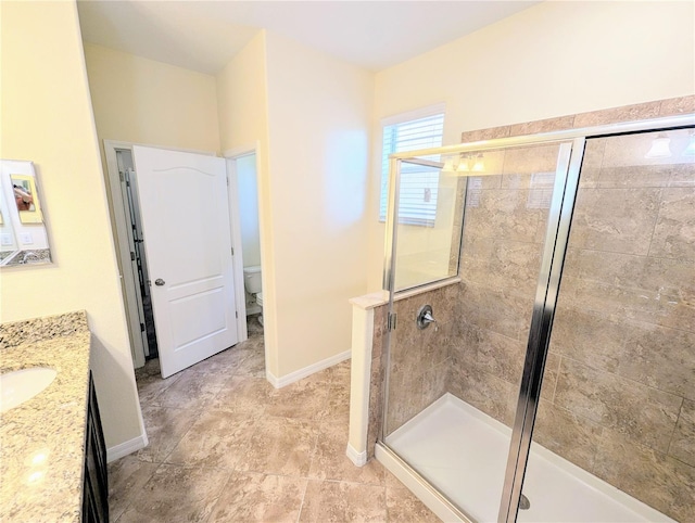 bathroom featuring an enclosed shower, vanity, and toilet