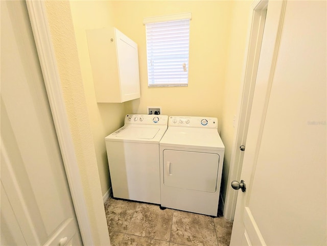 laundry area featuring washer and dryer and cabinets