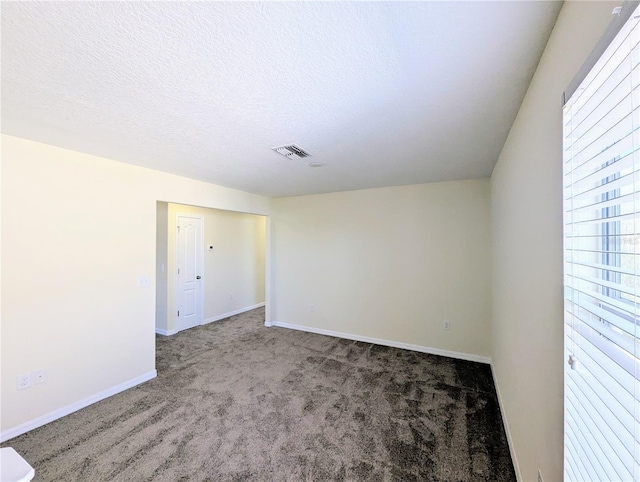 carpeted spare room featuring a textured ceiling