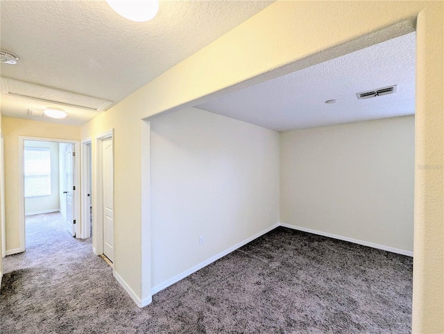 unfurnished room featuring carpet flooring and a textured ceiling