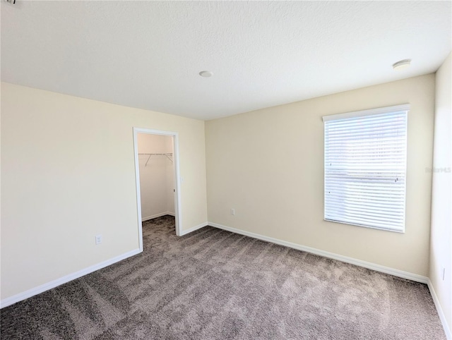 empty room with a textured ceiling and carpet floors