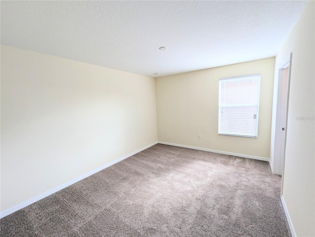 unfurnished room featuring carpet floors and a textured ceiling