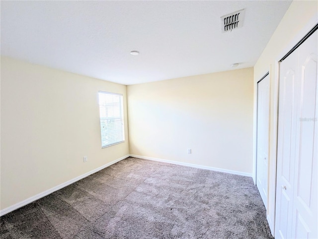 unfurnished bedroom with dark colored carpet