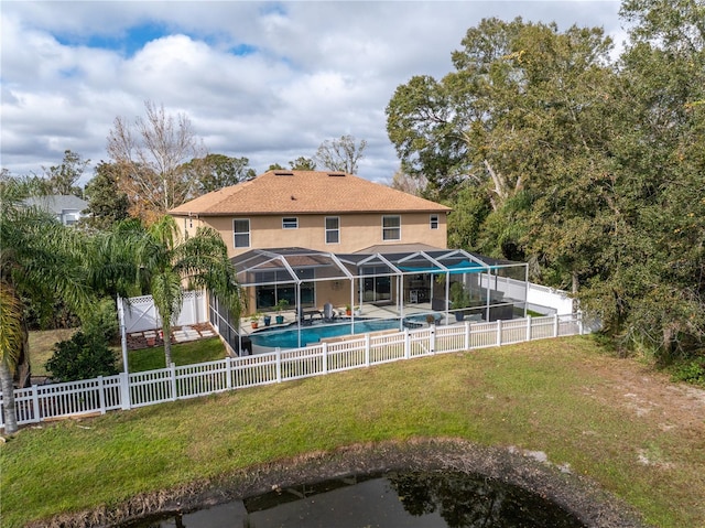 back of property featuring a fenced in pool, glass enclosure, a fenced backyard, a yard, and stucco siding