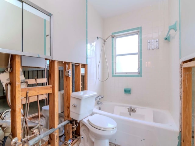 bathroom featuring tiled shower / bath combo and toilet