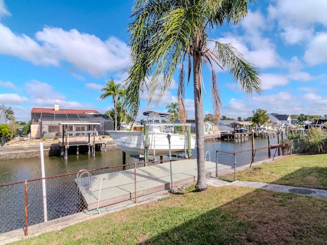 view of dock with a lawn, glass enclosure, and a water view