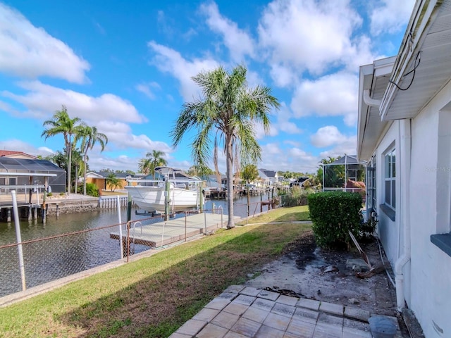 view of yard featuring a lanai, a boat dock, and a water view